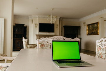 Laptop computer with green screen in room