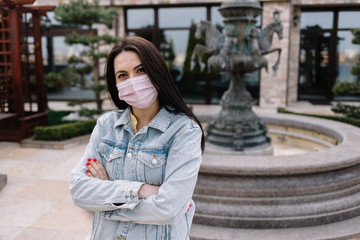 Fototapeta premium COVID-19 Pandemic Coronavirus Woman in city street wearing face mask protective for spreading of disease virus SARS-CoV-2. Girl with protective mask on face against Coronavirus Disease 2020.