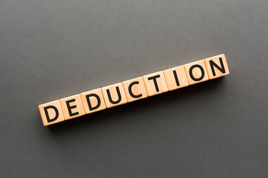Deduction - word from wooden blocks with letters, the process of reaching a decision or answer deduction concept, black background