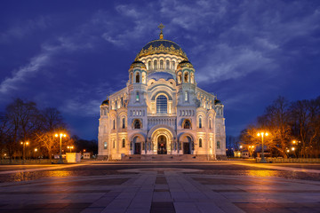 Fototapeta na wymiar Naval Cathedral in Kronstadt. The best sunset of the evening city. Illumination of the building. Square and evening lights. Traveling in Russia