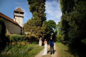 Fototapeta na wymiar Beautiful wedding couple posing on the way to the old medieval stronghold