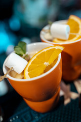 Mug with citrus and mashmelo hot drink on a bar counter