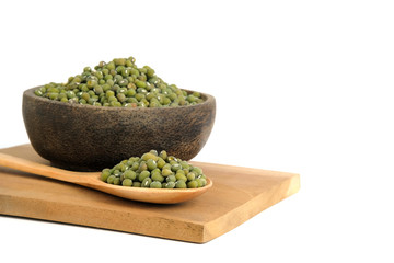 Close up raw green mung seed on wooden bowl and spoon above cutting board isolated on a white background