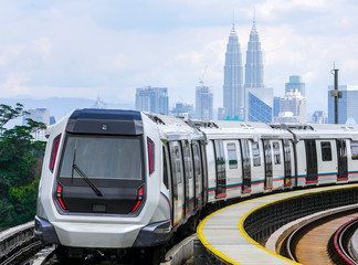 Malaysia Mass Rapid Transit (MRT) train with a background of Kuala Lumpur cityscape. People commute...