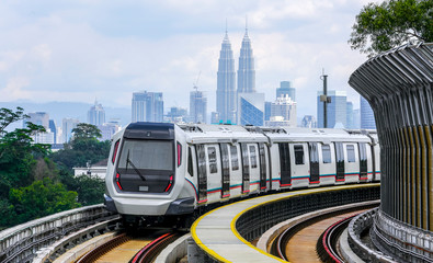 Malaysia Mass Rapid Transit (MRT) train with a background of Kuala Lumpur cityscape. People commute with MRT as transportation to work, school, travel, and shopping.
