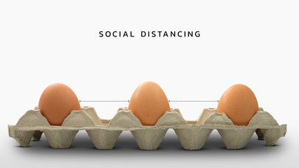 three eggs in box with white background and text social distancing