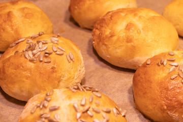 Home made bread rolls or buns for breakfast fresh on a paper on a table, selected focus, narrow depth of field
