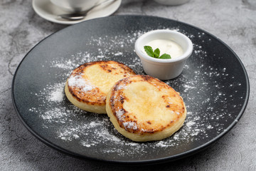 Traditional Russian cuisine: cottage cheese patties with sour cream