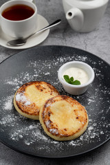 Traditional Russian cuisine: cottage cheese patties with sour cream