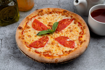 Classic mini-pizza margherita with tomatoes and melted cheese, a psrt of kids menu in a cafe