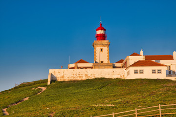 Fototapeta na wymiar Cabo da Roca, Portugal - white lighthouse on cliffs at evening time.
