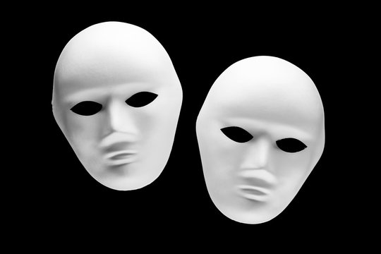 Two human face masks isolated on black background
