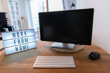 Working from home remote work inspirational social media lightbox message board next to monitor and keyboard and mouse, COVID-19 quarantine closure of all. Apartment background