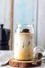 Iced latte with frozen espresso cubes, Iced coffe with milk on a white stone table