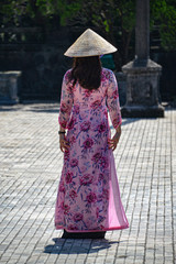 A chinese woman walking along a temple