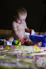 little baby playing happily at home with his colorful toys, at home he is comfortable