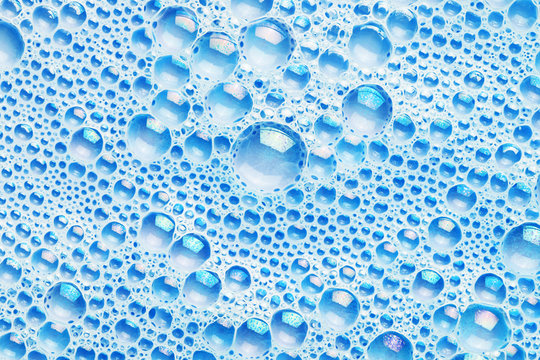 Water foam texture. Blue bubble spa background. Foam structure backdrop. Shapoo soap washing pattern.