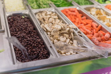 Black bean, sliced mushroom, carrot and tofu at salad bar in high-end grocery store in USA