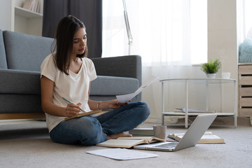 Coronavirus. Beautiful young smiling woman in quarantine working on laptop from home.