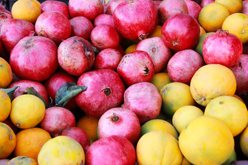 natural orange oranges and red pomegranates on the market