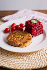 veggie burger  on plate with red rice and tomato