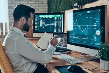 Good looking young modern man in formalwear working using comput