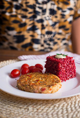 veggie burger  on plate with red rice and tomato