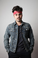 Vertical portrait of serious hipster with confident expression, wears denim jacket, isolated over white background.