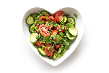 Fresh salad with tomato, cucumber, vegetables, microgreen radishes. Top view. Concept vegan and...