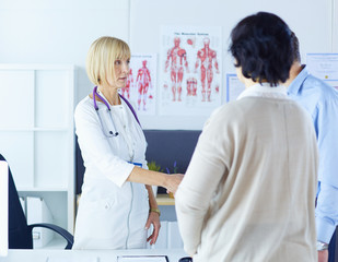 Obraz premium Female doctor handshaking a patient's hand and smiling
