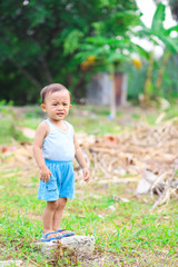 Little Asian child in the park, Moody boy standing in garden