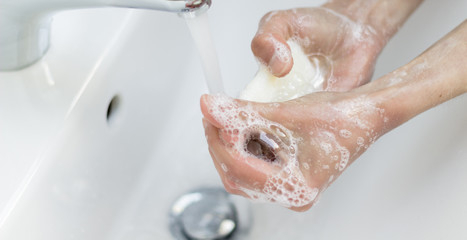 woman washing hands under water tap in a white sink. Preserve virus infection, wash your hands.