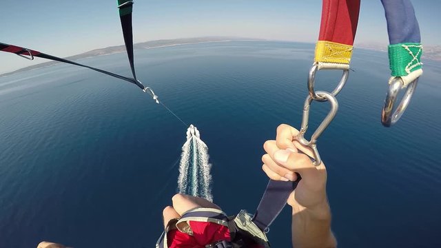 Amazing parasailing over Adriatic sea Croatia. First person view of parachute slings and bar with carabiners high above crystal blue water