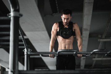 Naklejka na ściany i meble Man during workout in the gym Concept: power, strength, healthy lifestyle, sport. Powerful attractive muscular Man CrossFit trainer do battle workout with ropes at the gym. Young man exercising using