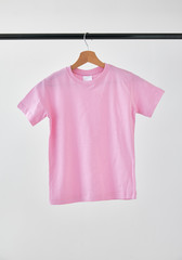 Blank pink T-Shirt mock-up hanging on white background.