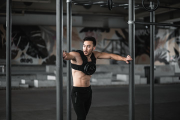 Man during workout in the gym  Concept: power, strength, healthy lifestyle, sport. Powerful attractive muscular Man CrossFit trainer do battle workout with ropes at the gym. Young man exercising using