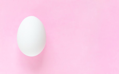 Easter egg on pastel pink background with copy space