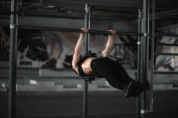 Naklejka premium Man during workout in the gym Concept: power, strength, healthy lifestyle, sport. Powerful attractive muscular Man CrossFit trainer do battle workout with ropes at the gym. Young man exercising using