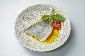 fish steak with vegetable and basil served on table