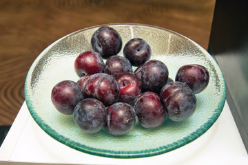 Group of plum on glass plate . Fresh plums in plate .