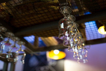 Empty wine or cocktail glasses hang on the bar in a bar or pub