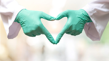Thank you coronavirus helpers concept. Hand of doctor in heart shape isolated on hospital blur...