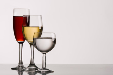 Different shapes of wine glasses with wine in a studio