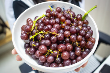 Red grapes in a white bowl