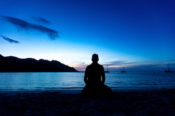 Méditation au coucher de soleil sur la plage à Moorea