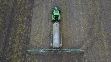 Traktor mit Güllefass und Schleppschuhverteiler bringt Gülle auf Acker aus, Vogelperspektive © keBu.Medien