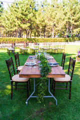 Fototapeta premium Preparing for an open-air party. Decorated with fresh flowers served tables. Table number. Decoration Details
