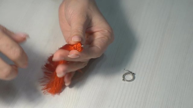 Handwork at home. A woman makes a jewelry from threads for women with her own hands.