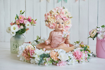 Sweet funny baby in hat with flowers. Easter greeting card, copyspace for your text. Poster for Easter holiday. Congratulations on Mother's Day. Cute baby girl 6 months wearing flower hat.