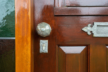 Fototapeta premium Front door with stained glass and metal door knob, vintage design close-up